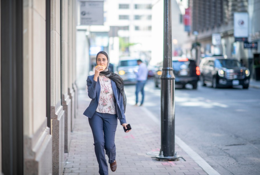 Lady eating a sandwich on the go, highlighting fast eating habits linked to type 2 diabetes risk