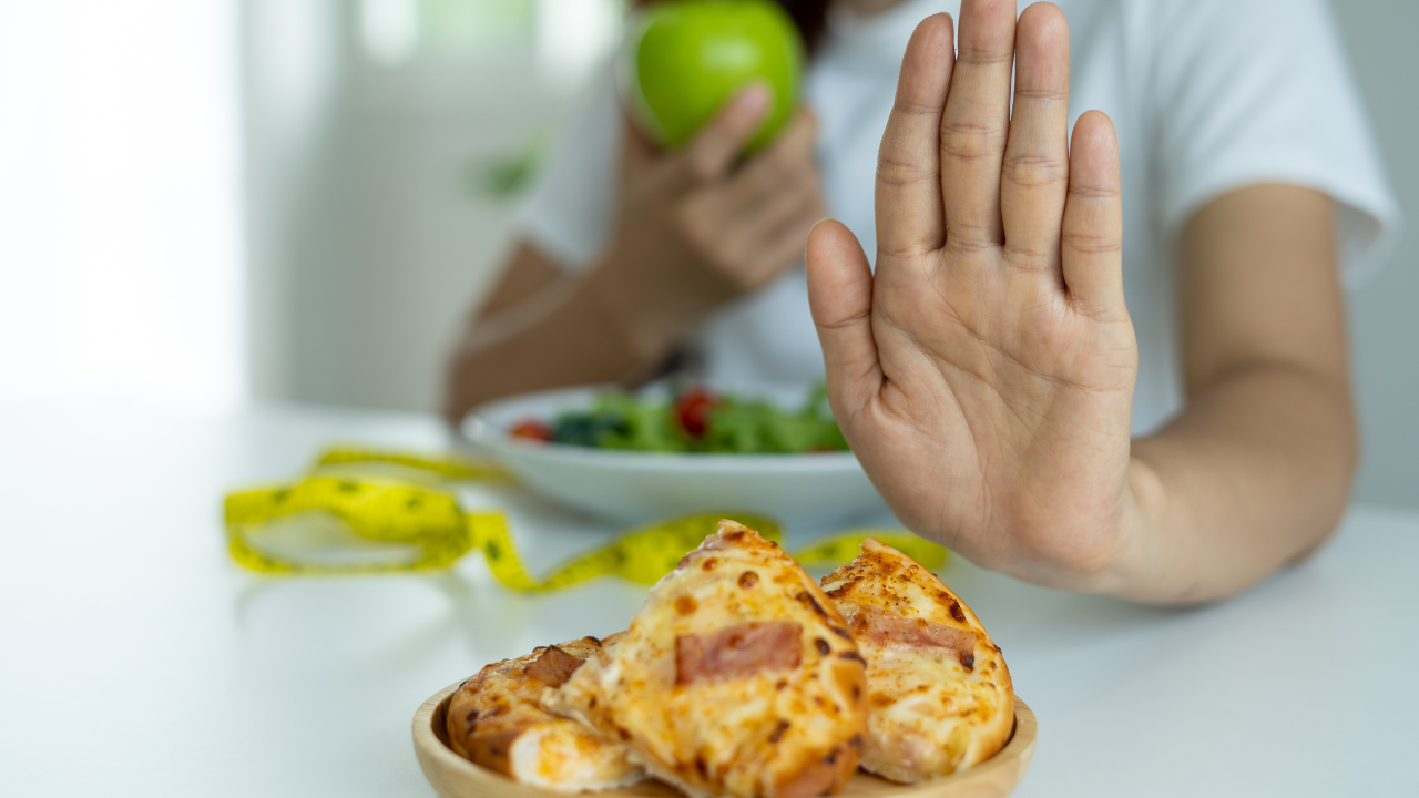Hand refusing unhealthy foods and selecting a balanced meal, illustrating self-discipline for blood sugar control
