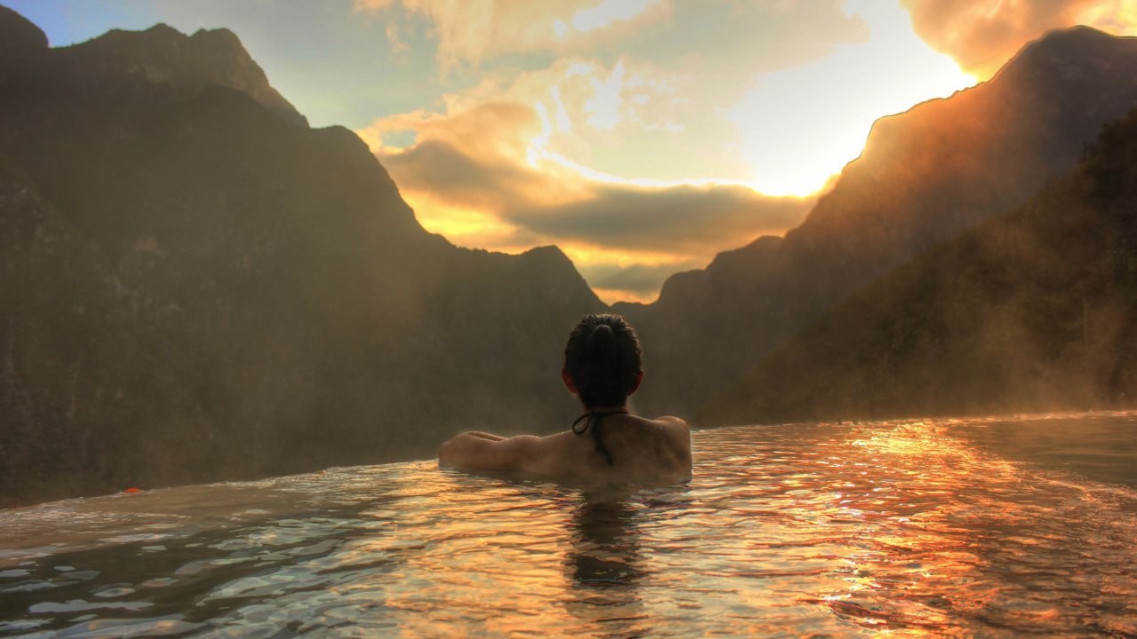 Woman enjoying a pool with a scenic view, representing a healthy lifestyle and how to reverse type 2 diabetes while travelling