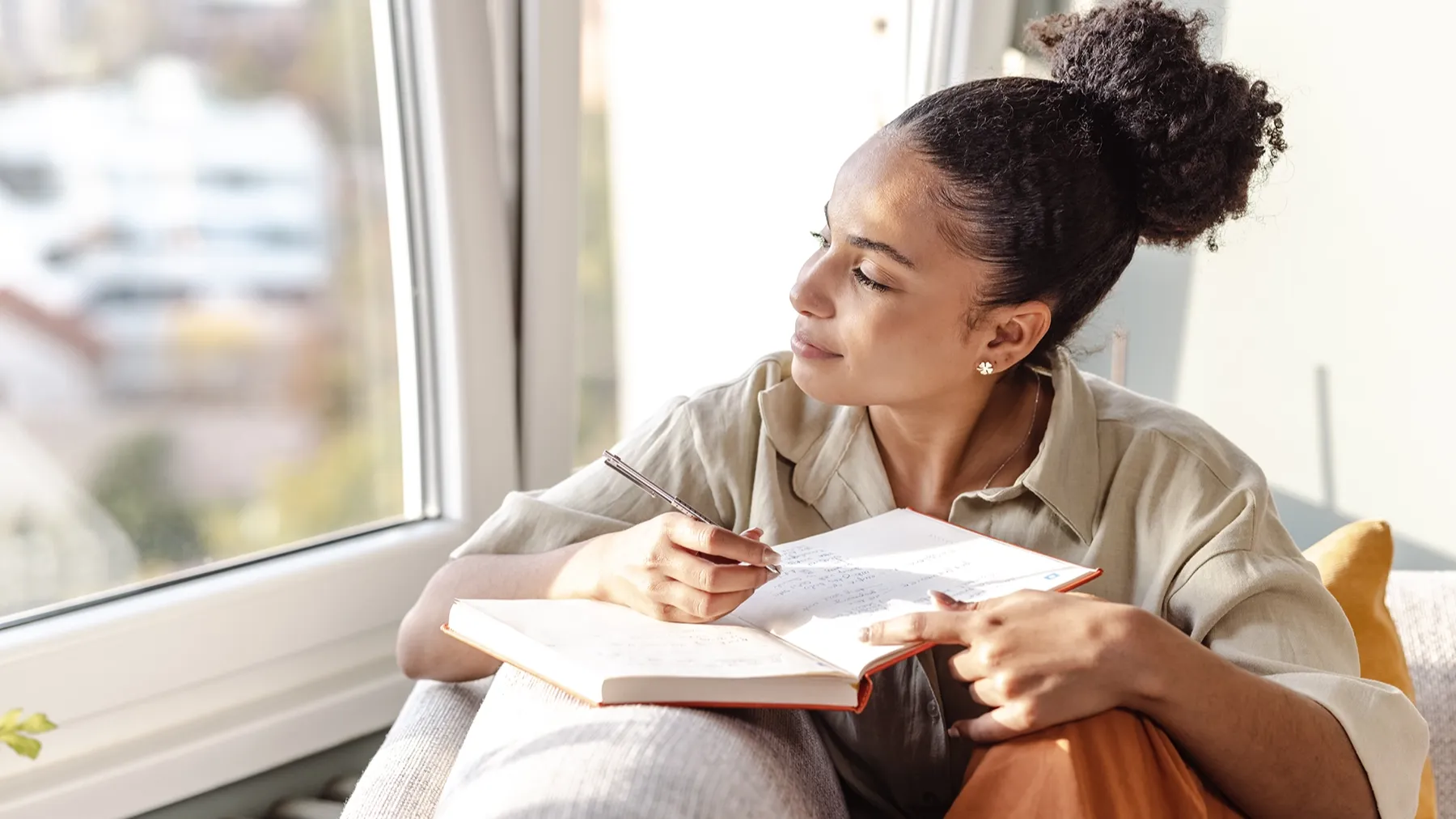 Woman sitting and writing in a journal reflecting on her diabetes management and emotional health