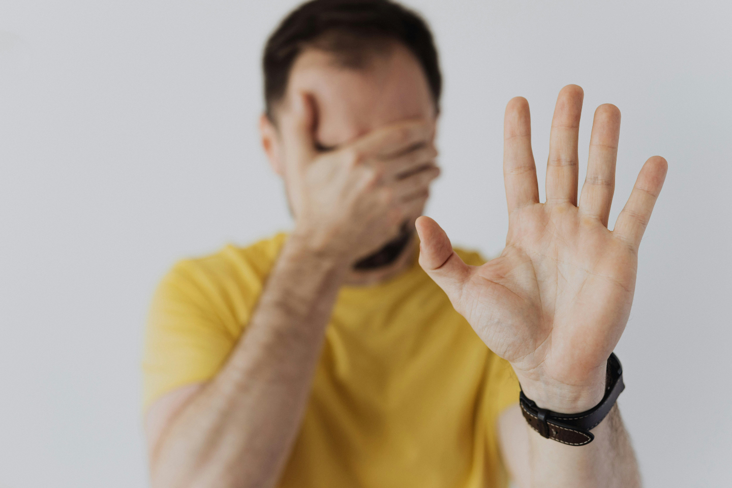 Man raising one hand to stop and covering his face with the other, illustrating avoidance behaviours that can hinder type 2 diabetes management
