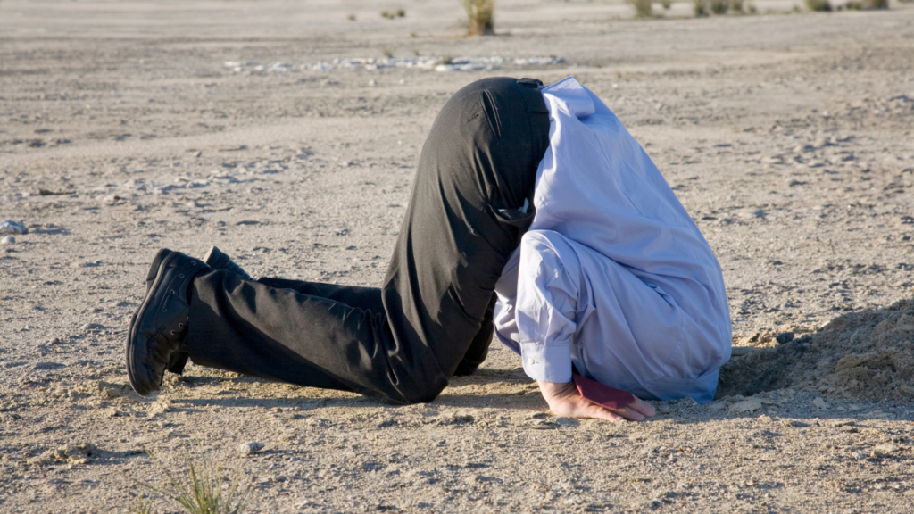 A person with their head buried in the sand symbolising avoidance of type 2 diabetes reality