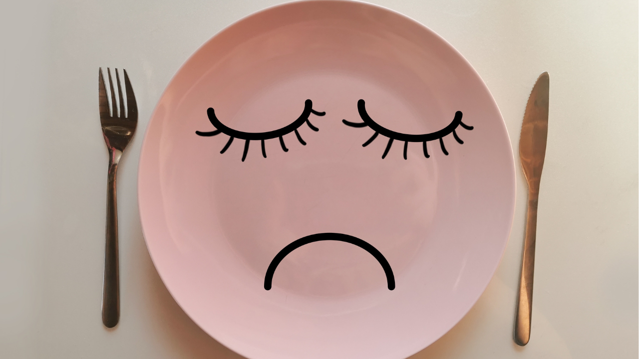 Dinner plate with a sad face representing emotional or habitual hunger that affects diabetes management