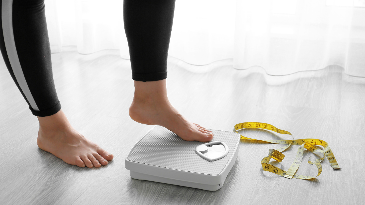 Woman standing on weighing scales, representing weight management strategies for post-menopausal women aiming to reverse type 2 diabetes