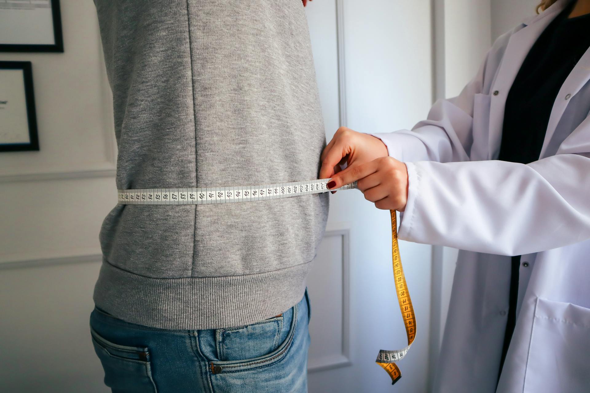 Health professional measuring a patient’s waist as part of assessing insulin resistance and type 2 diabetes risk