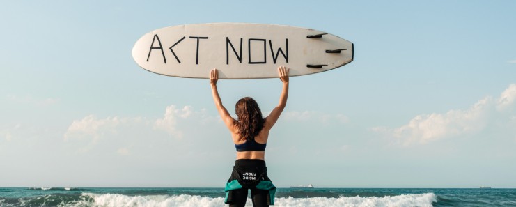 Woman holding a surfboard with "Act Now" representing taking action to reverse type 2 diabetes