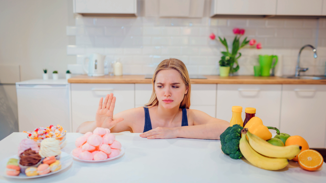 A woman holding her hand up to refuse sugary foods as part of reversing type 2 diabetes naturally